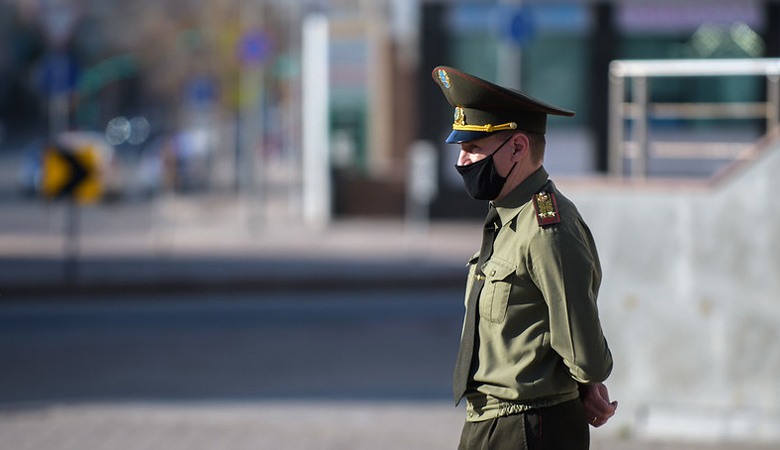 A Kazakh soldier wearing a protective mask stands on duty